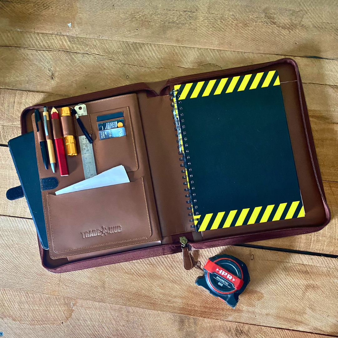 Open TradeHub Work Folder with black and yellow notepad, ruler, pens and torch