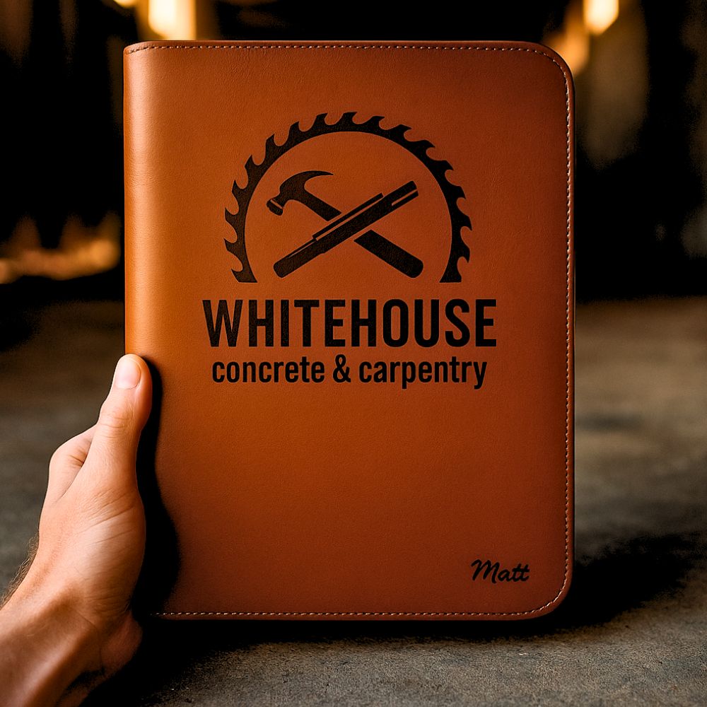 Man holding brown leather compendium with 'WHITEHOUSE Concrete & Carpentry' logo in construction setting