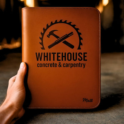Man holding brown leather compendium with 'WHITEHOUSE Concrete & Carpentry' logo in construction setting