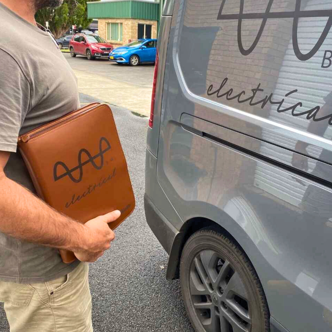 Electrician with branded folder matching business van signage