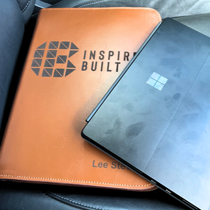 Leather TradeHub folder with Inspire Built logo next to a Microsoft Surface tablet